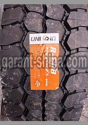 Unicoin R-208 (универсальная) 385/65 R22.5 164K 24PR - Фото протектора с этикеткой вблизи